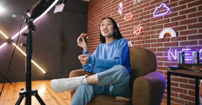 Content creator recording video in studio with professional lighting and neon signs for affiliate marketing platforms guide.