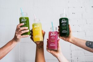 How To Write A Killer Influencer Brief In 10 Steps - a variety of colorful juices held up by four hands