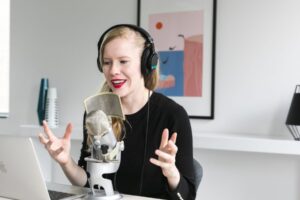 woman recording podcast at mic scaled 1