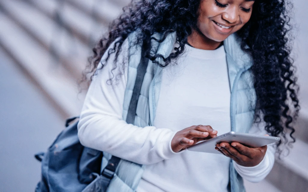 a person smiling at their phone, scrolling offers while walking on the street